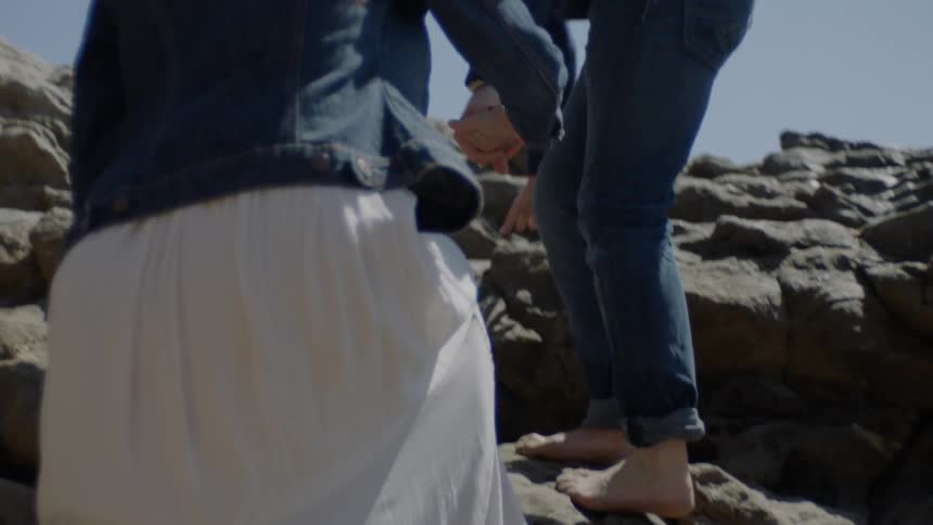 A couple i s climbing a cliff