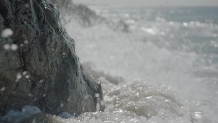 Ocean waves crash into a rock