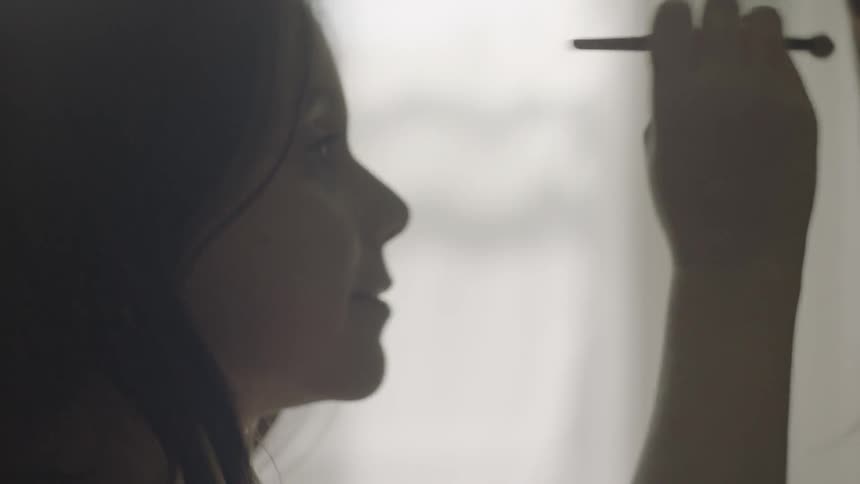 A little girl putting makeup on a woman's face