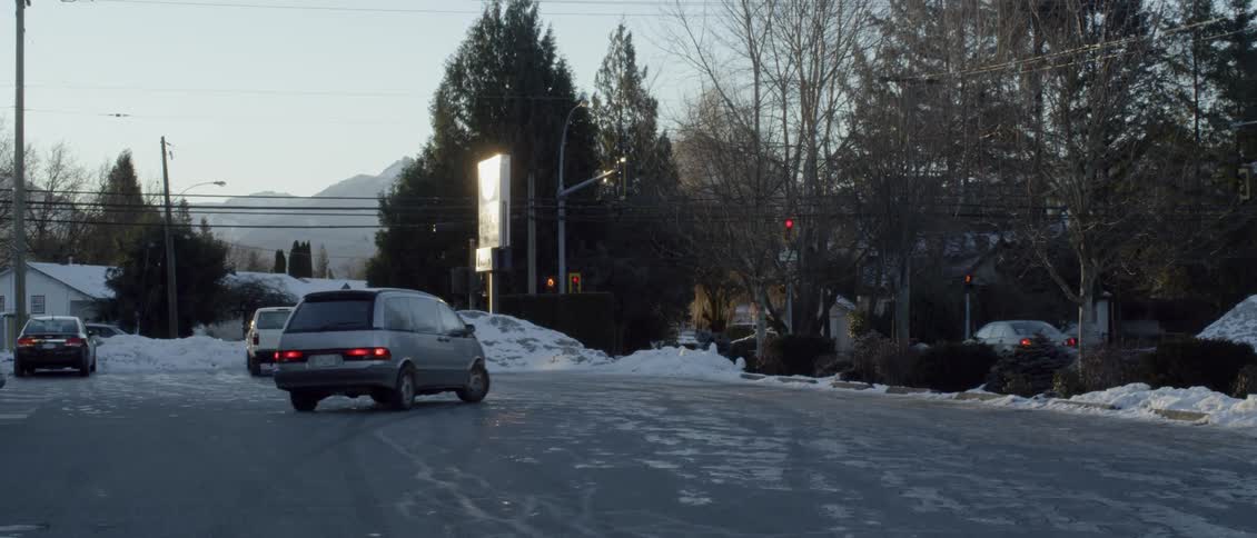 The car makes a turn on the small road to park
