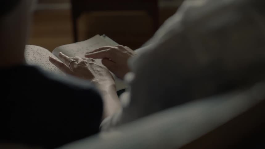 A woman reads braille