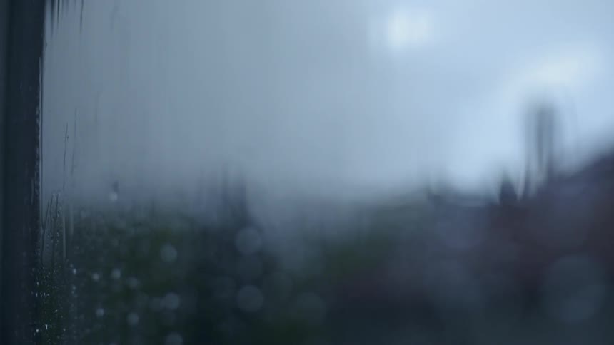 Water drips down a window on a rainy day