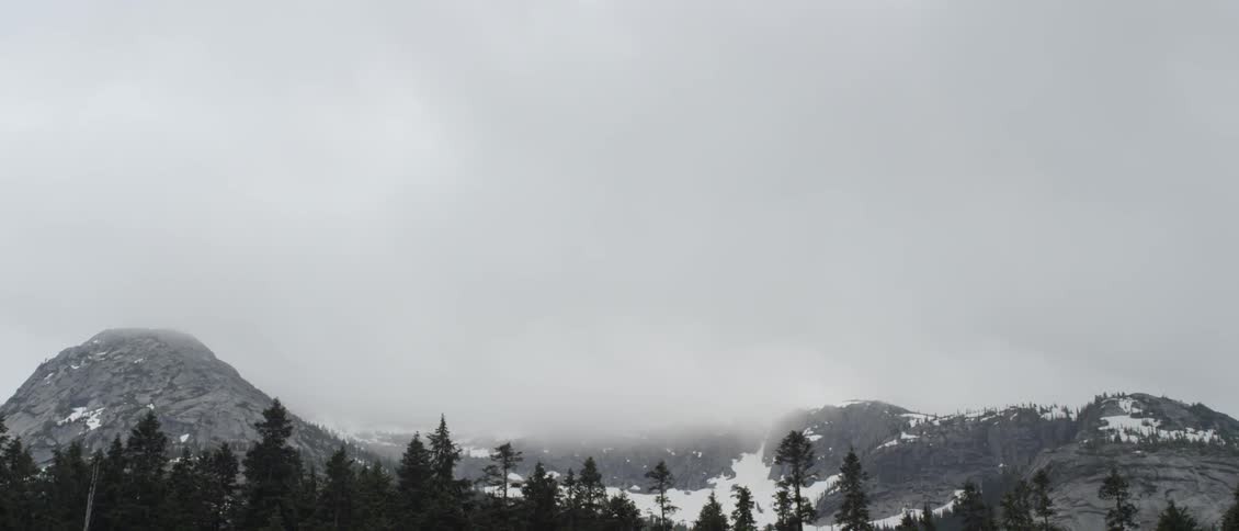 Heavy clouds roll over the snow covered mountain