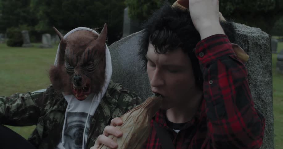 A boy removes his mask so he can drink from a bottle