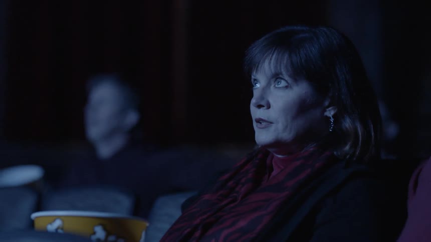 A man yells at a woman in a movie theater