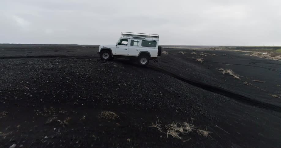A vehicle drives across a dirt field