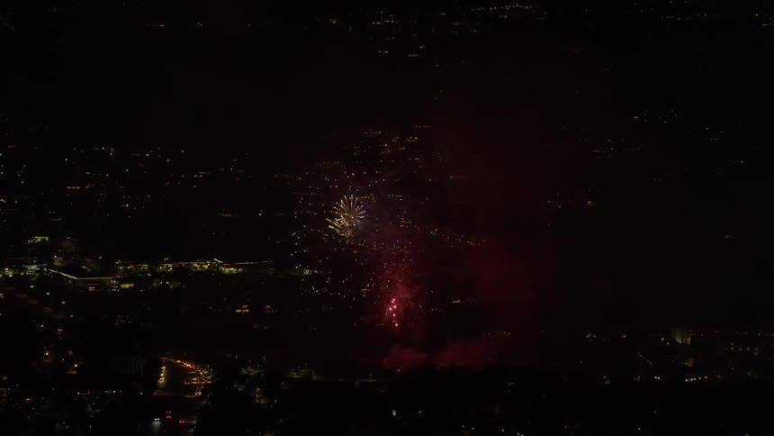 Fireworks explode in a dark night sky