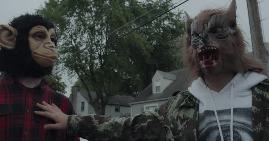 Boys wearing masks and carrying an egg carton stop walking