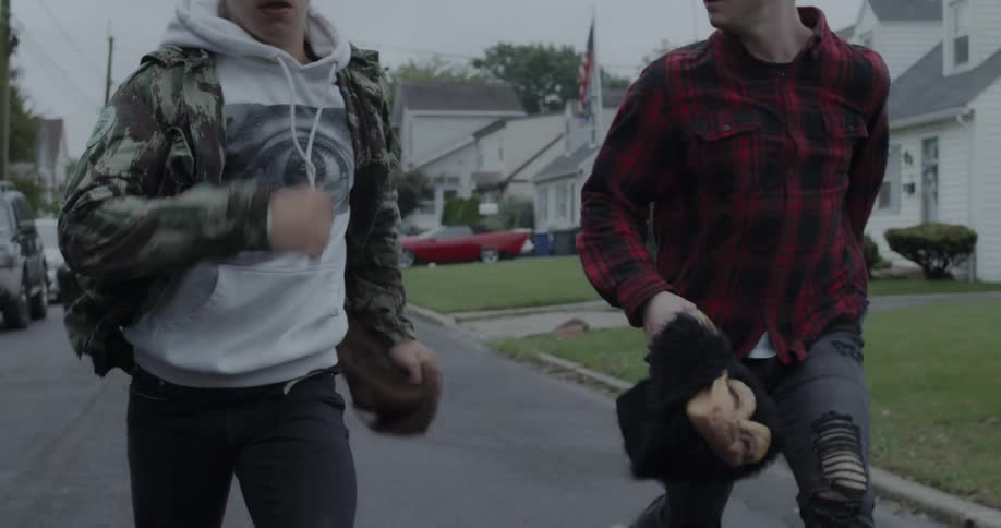 Two boys run frantically on a neighborhood street