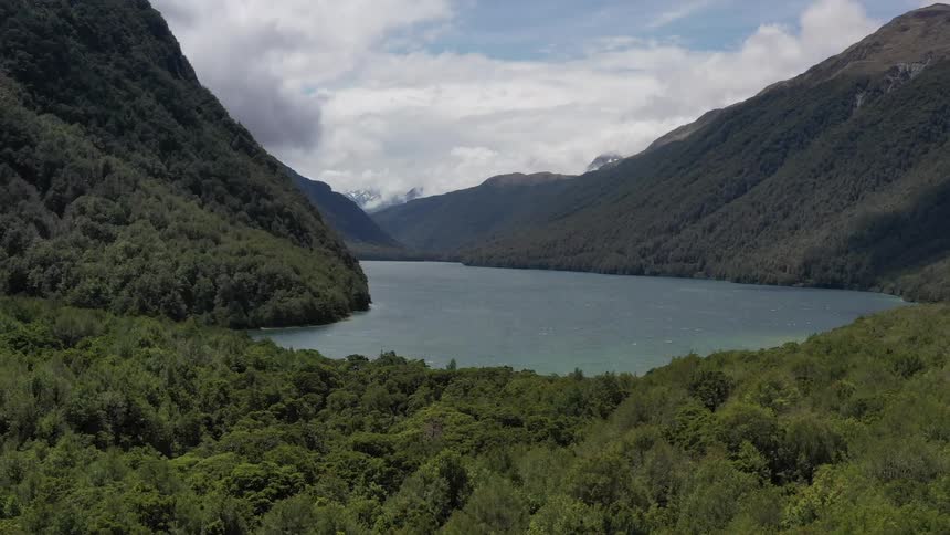 The green hills have a small body of water below