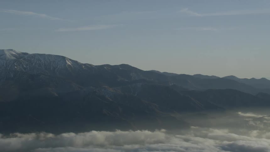 Clouds float near mountains