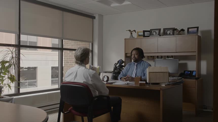 Two men speak together in the office