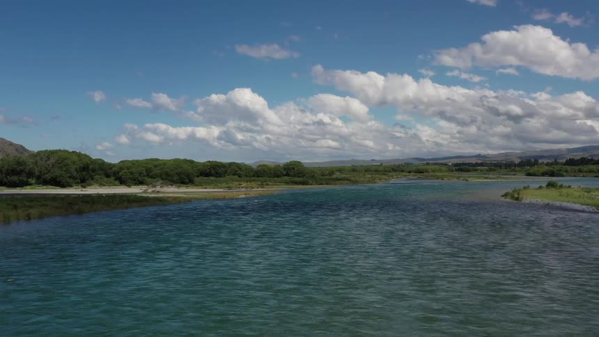 Large blue lake with white clouds overhead