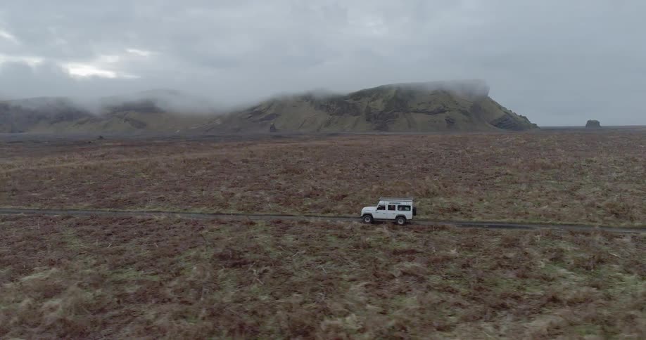 A jeep drives down the dirt road
