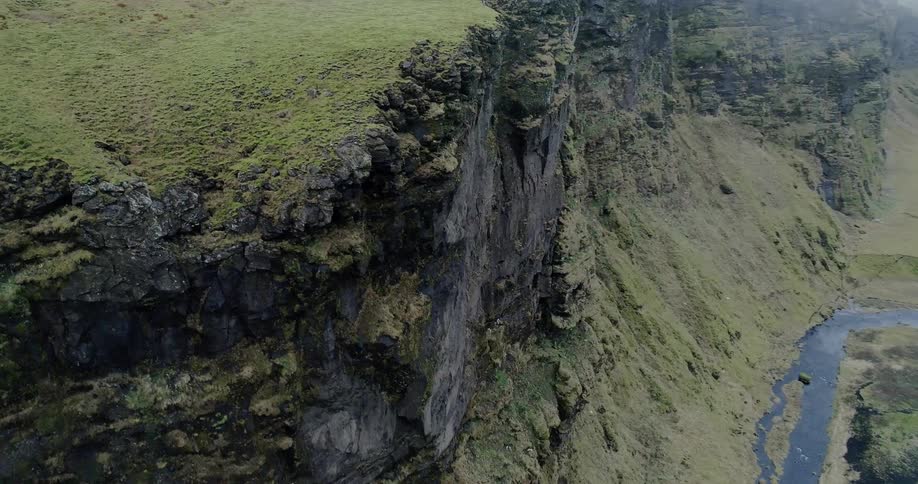 Grass and moss cover a rocky cliff