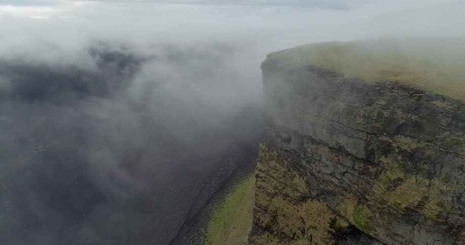 A fog bank is below the cliff