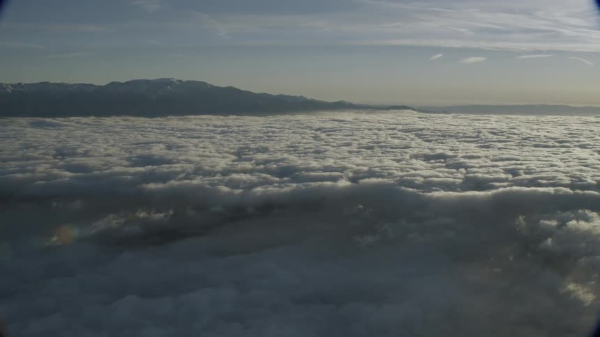 White fluffy clouds move above the mountains