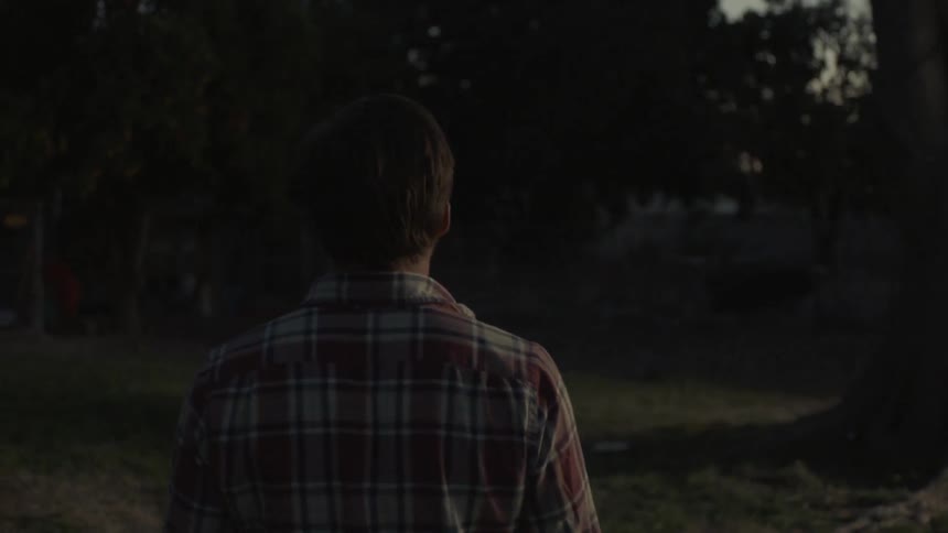 A man is walking outdoors in a rural neighborhood