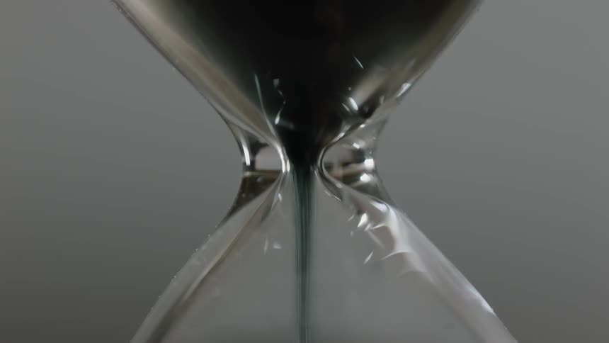 Sand falls in an hourglass