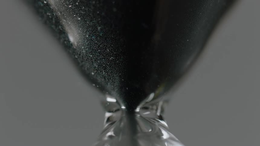 Sand falls in an hourglass