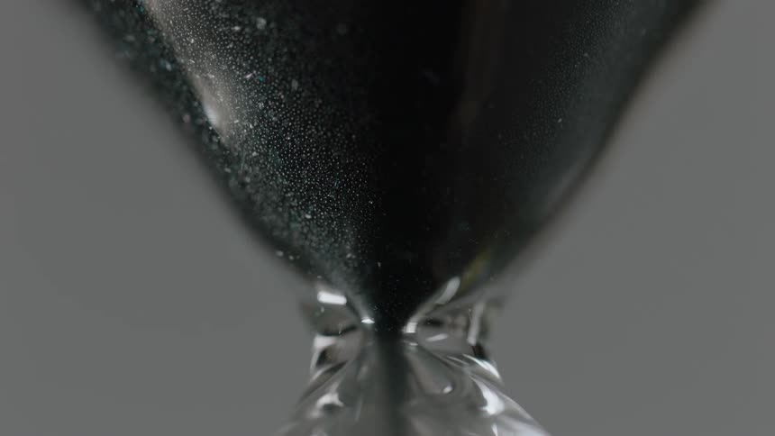 The sand slowly pours down in the hourglass
