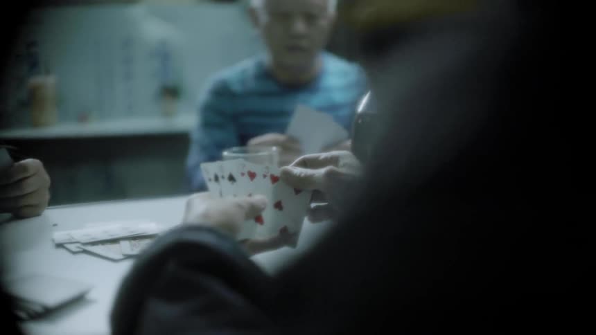 Men play cards while drinking