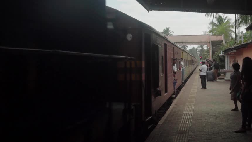 People wait as the train slowly stops at the station