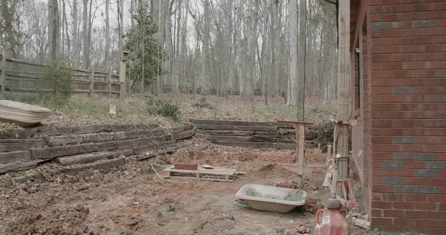 Construction equipment is set up outside of a brick house