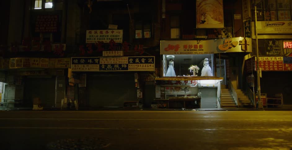 Shops line a city street at night
