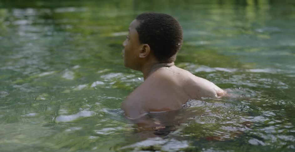 Child splashes and wades in a lake
