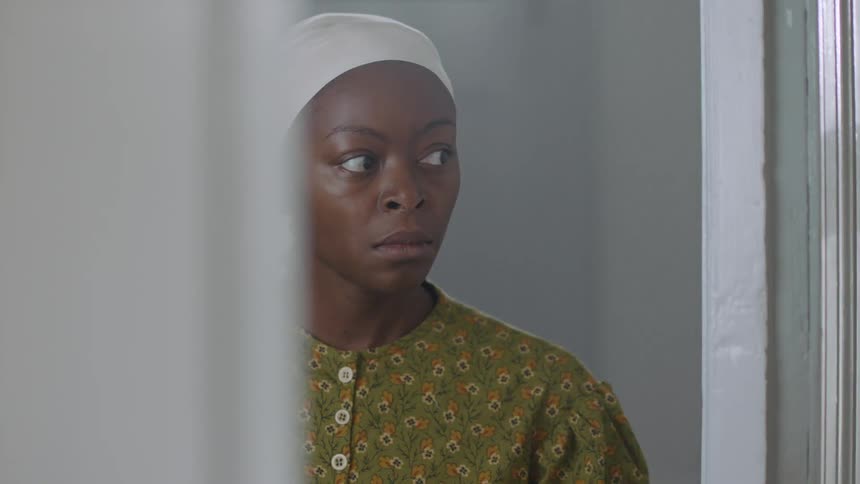 A woman pauses in a doorway before walking through