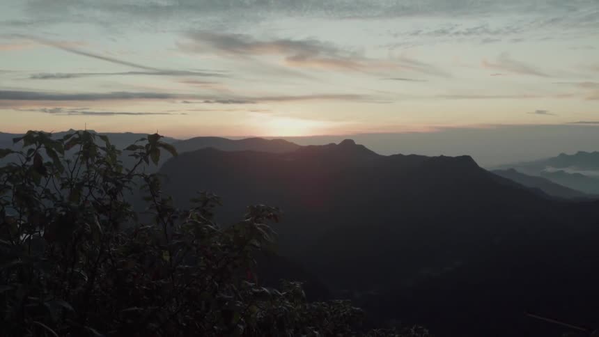 Sun sets over hills and trees