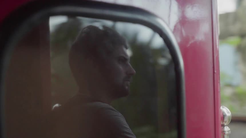 A man rides on a red train