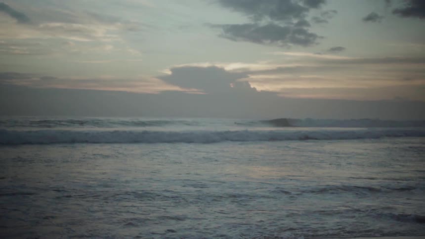 Ocean waves splash at sunset