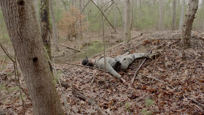 A dead body lies in a forest