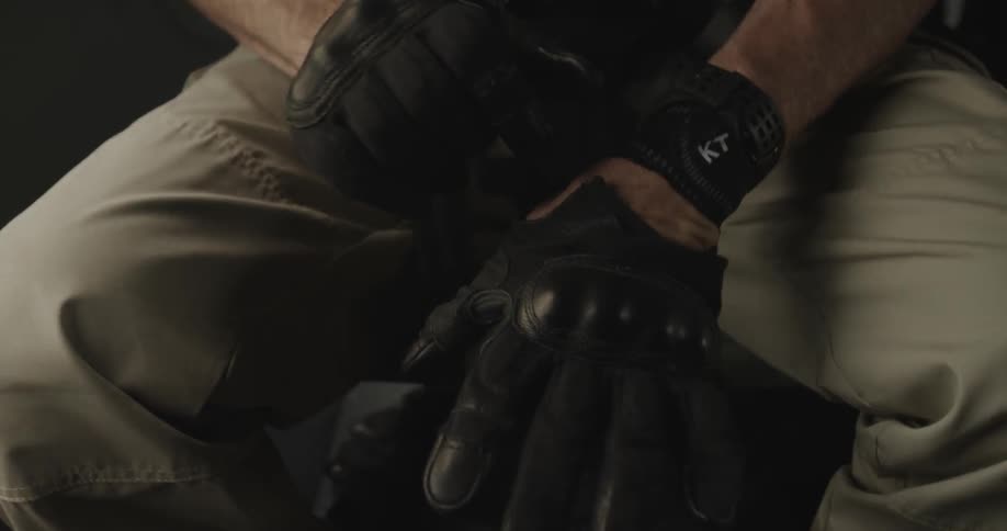A man is putting gloves on