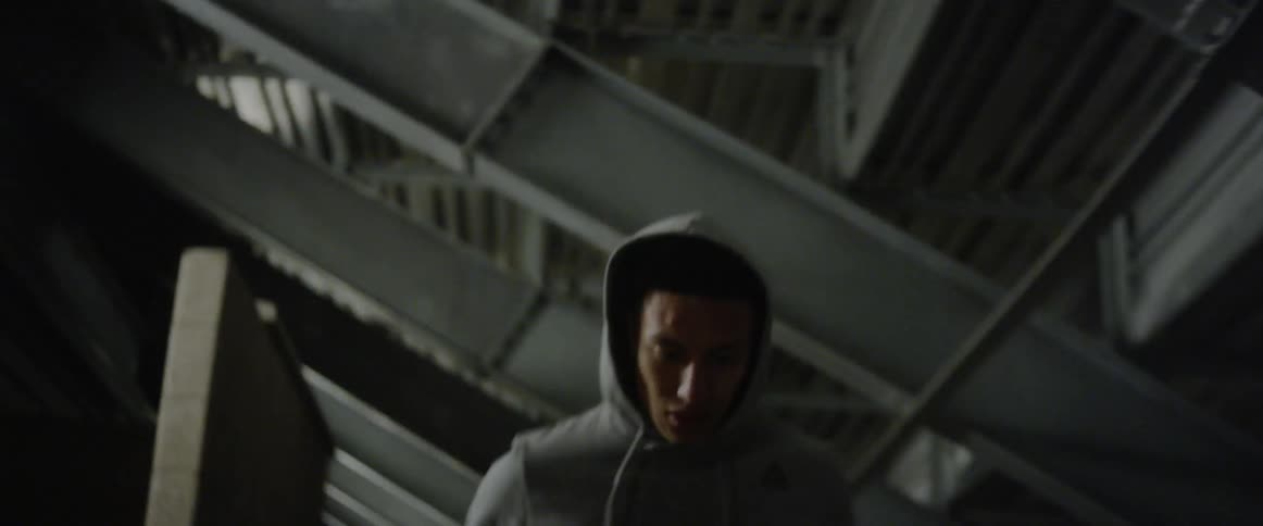 A man jogs beneath bleachers at night