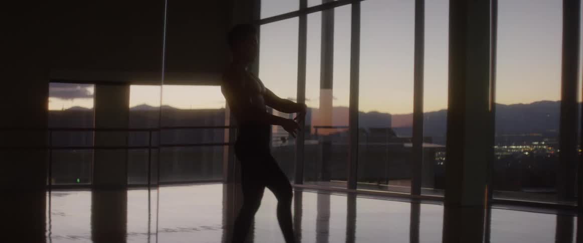 A man dances in a studio at sunset