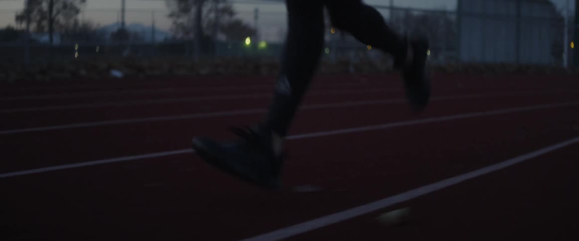 A person is running on the track at sunset