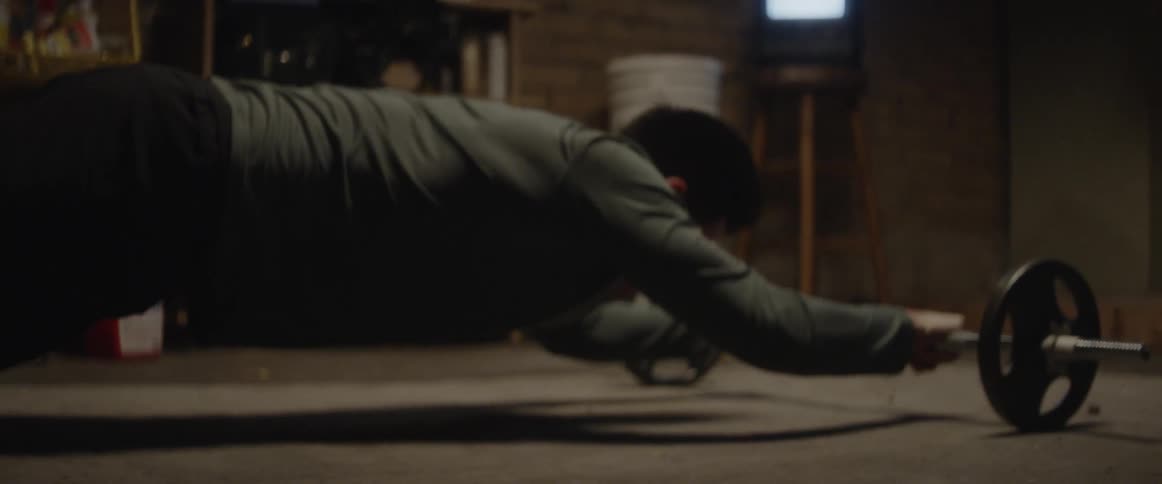 A man does a rolling exercise with weights
