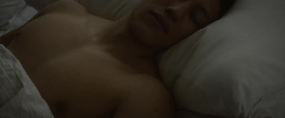 Shirtless man sleeps in bed