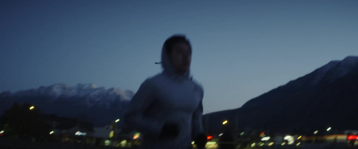 A man is jogging outside by the road at sunset