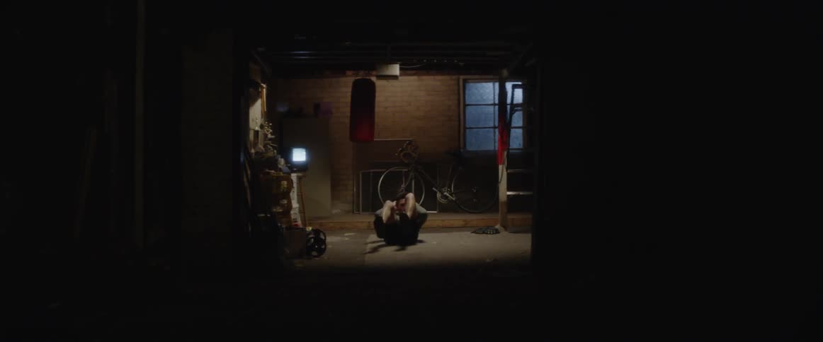 Man is doing bicycle crunches exercise on floor of gym