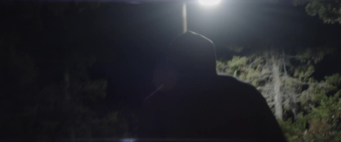 A man stretches outside at night