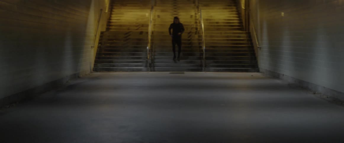 Man in hoodie jogs down steps