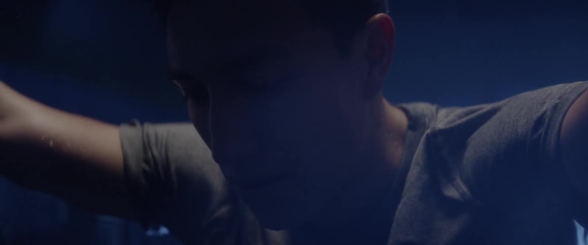 A man leans forward sweating