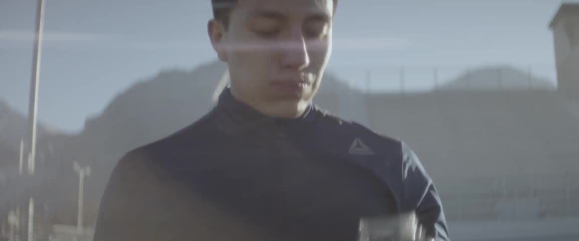 A man is drinking from a jar on the field