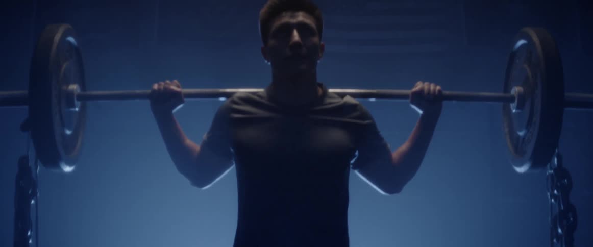 A man does squats with a heavy weight