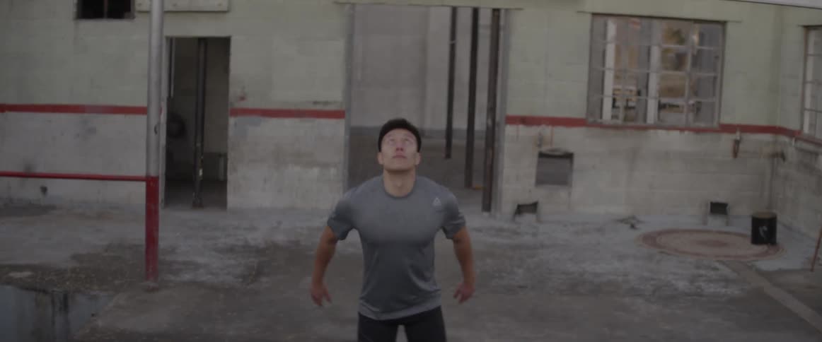 A man stretches and does pull ups on a rafter