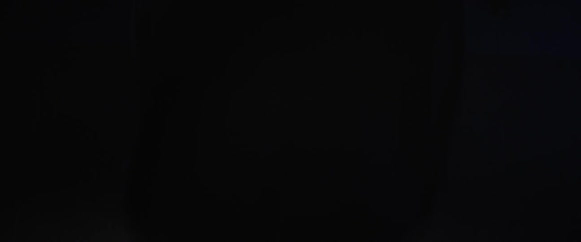 A man is doing pull ups in the dark